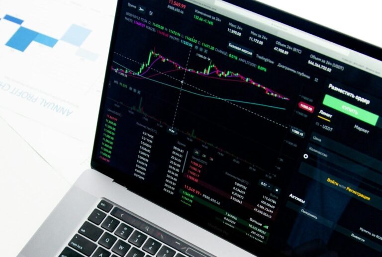 Professional analyzing stock market graphs on a laptop, showcasing investment insights.